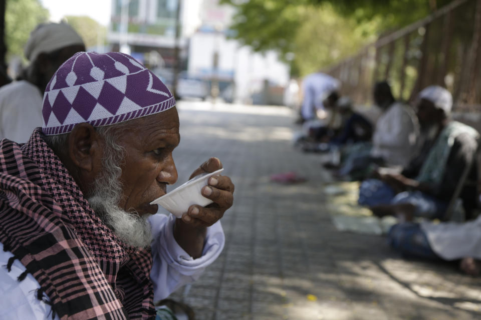 A homeless man eats Kheer, a sweet dish distributed by a Muslim man on Eid al-Fitr in Ahmedabad, India, Monday, May 25, 2020. The holiday of Eid al-Fitr, the end of the fasting month of Ramadan, a usually joyous three-day celebration has been significantly toned down as coronavirus cases soar. (AP Photo/Ajit Solanki)