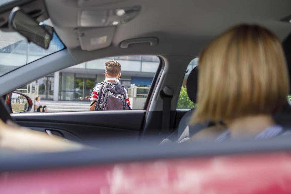 parent in their car watching their son walk into school