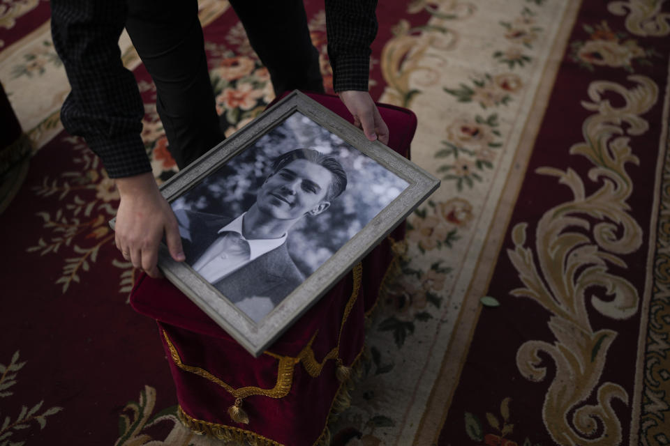 A man holds a photo of activist and soldier Roman Ratushnyi before the start of the memorial service in Kyiv, Ukraine, Saturday, June 18, 2022. Ratushnyi died in a battle near Izyum, where Russian and Ukrainian troops are fighting for control of the area. (AP Photo/Natacha Pisarenko)