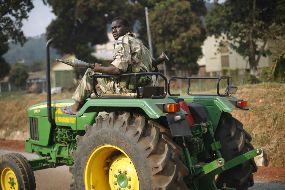 A Seleka Muslim militiaman holding a RPG drives a tractor through Bangui, Central African Republic, Monday Jan. 27, 2014, after evacuating the Camp de Roux downtown to relocate and join other Selekas at the PK11 camp. The clearing out of Camp de Roux — normally the army's main base in the capital — comes more than two weeks after rebel leader-turned-president Djotodia surrendered power amid mounting international condemnation of his inability to stop sectarian bloodshed. A new interim civilian government has pledged to halt the violence and attempt to organize elections no later than February 2015. (AP Photo/Jerome Delay