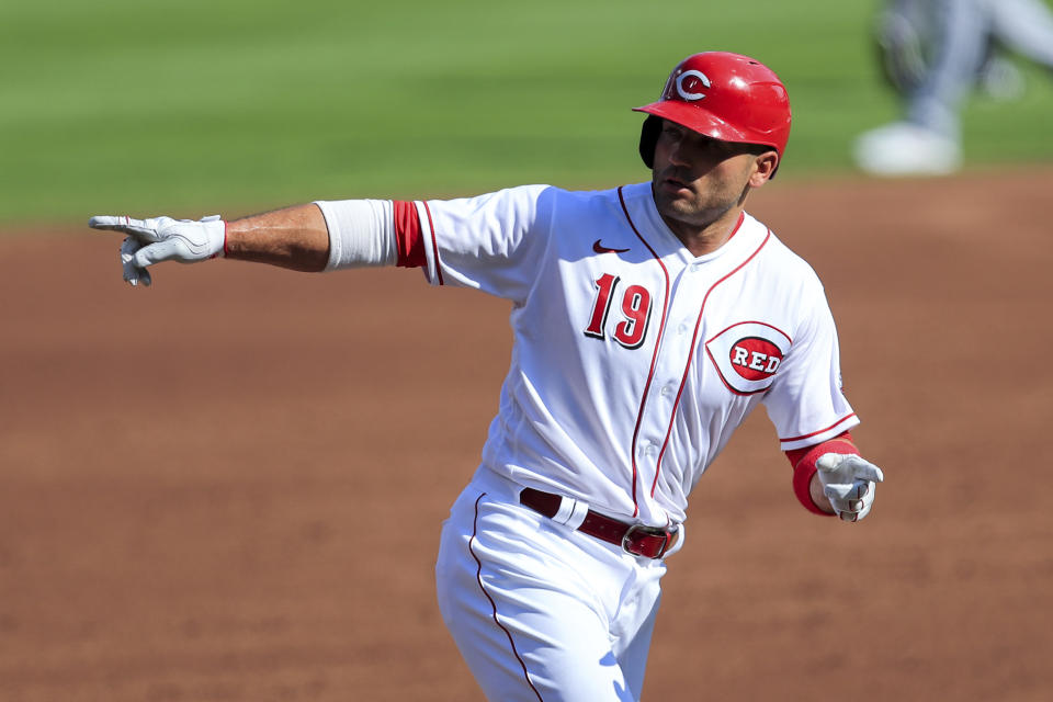 Cincinnati Reds' Joey Votto (19) points to members of the grounds crew after he hit a solo home run in the first inning during a baseball game against the Detroit Tigers at Great American Ballpark in Cincinnati, Saturday, July 25, 2020. (AP Photo/Aaron Doster)