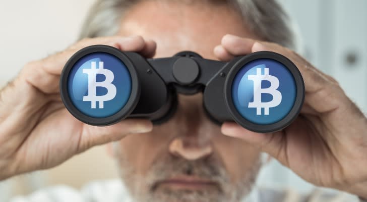 Man looking through binoculars and seeing the Bitcoin symbol