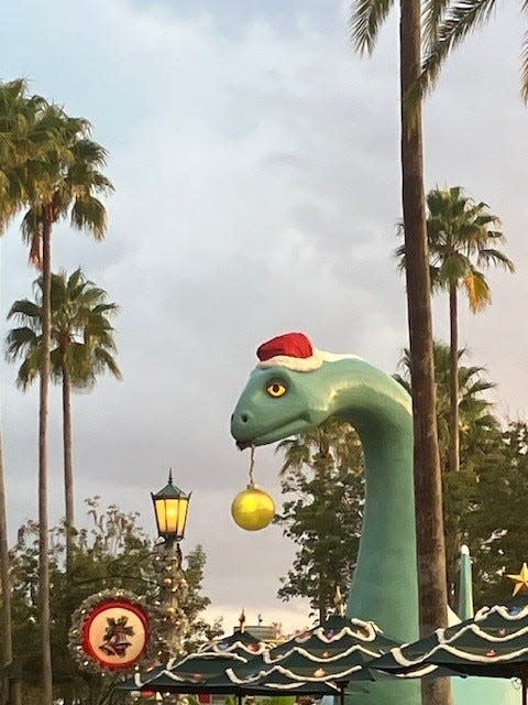 Gertie, of Gertie's Ice Cream of Extinction Fame, gets the merry on beside Echo Lake at Walt Disney World's Hollywood Studios.