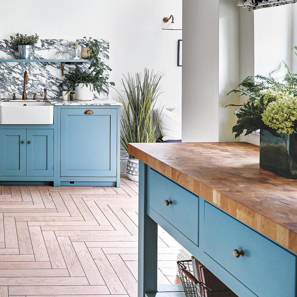 Kitchen with light blue cabinetry and blue freestanding kitchen island with wood worktop.