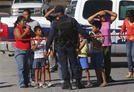 Family members of employees talk to a police officer after an explosion at a candy factory in Ciudad Juarez October 24, 2013. REUTERS/Jose Luis Gonzalez