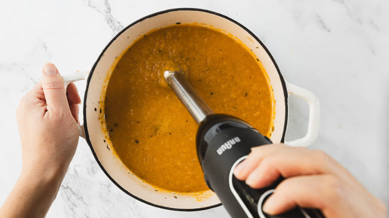 Blending carrot soup with immersion blender