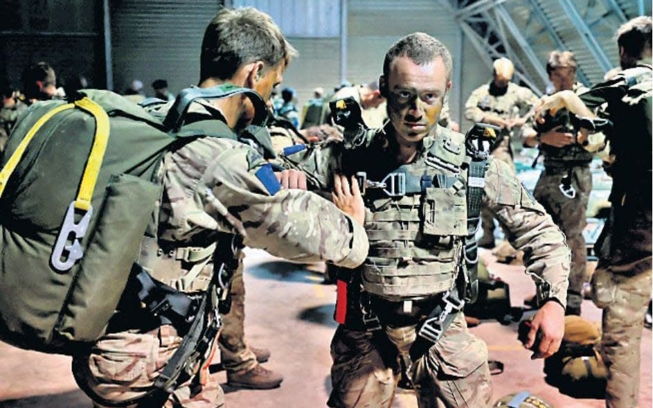 Paratroopers inspect each other's kit ahead of dropping into Jordan - PETER JORDAN