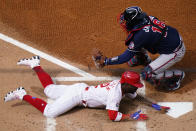 Philadelphia Phillies' Andrew McCutchen, bottom, scores past Atlanta Braves catcher Travis d'Arnaud on an RBI-sacrifice fly by Rhys Hoskins during the first inning of an opening day baseball game, Thursday, April 1, 2021, in Philadelphia. (AP Photo/Matt Slocum)