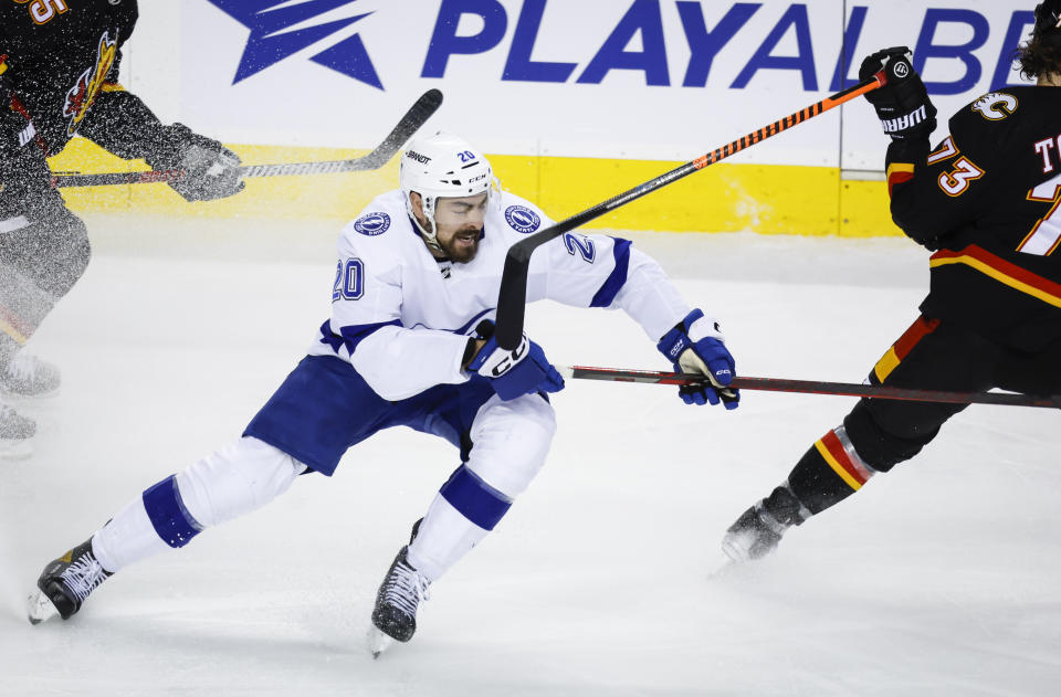 Tampa Bay Lightning forward Nicholas Paul, left, catches a stick to his face from Calgary Flames forward Tyler Toffoli during the second period of an NHL hockey game in Calgary, Alberta, Saturday, Jan. 21, 2023. (Jeff McIntosh/The Canadian Press via AP)