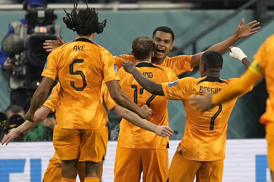 Cody Gakpo of the Netherlands, centre, celebrates with teammates after scoring his side's first goal during the World Cup group A soccer match between Netherlands and Ecuador, at the Khalifa International Stadium in Doha, Qatar, Friday, Nov. 25, 2022. (AP Photo/Martin Meissner)