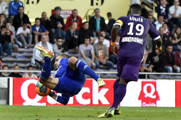 Lyon's goalkeeper Anthony Lopes (L) catches the ball next to Toulouse's defender Serge Aurier during a French L1 football match on April 23, 2014 at the Municipal Stadium in Toulouse, southern France