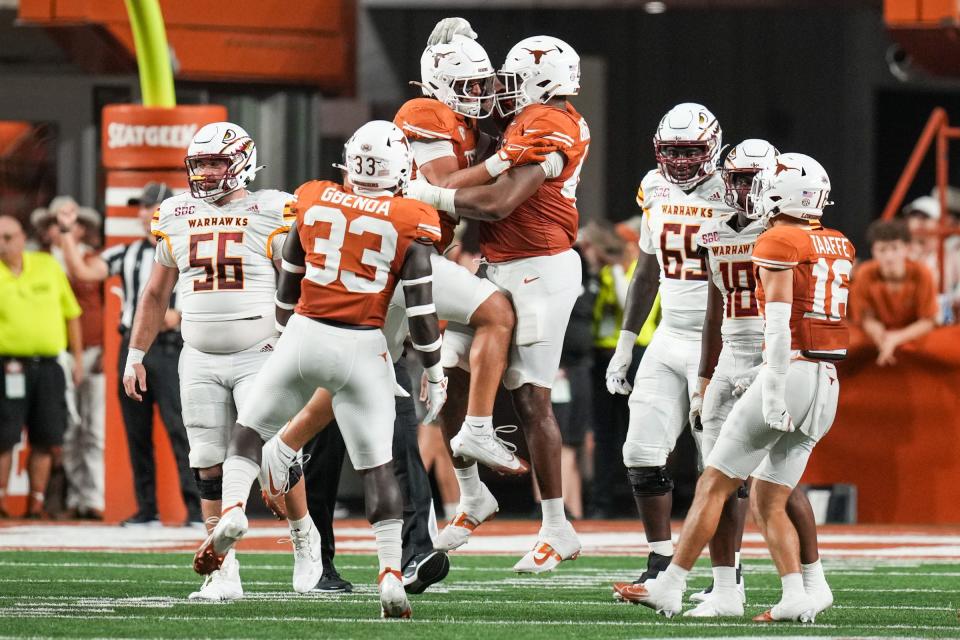 Texas linebacker Liona Lefau, center, celebrates with his teammates after pulling down Louisiana-Monroe quarterback General Booty for his second sack of the season Saturday at Royal-Memorial Stadium. Lefau says a tight bond with his teammates, strengthened by a group trip to Lefau's hometown in Hawaii this past summer, has helped him enjoy a breakout sophomore season.