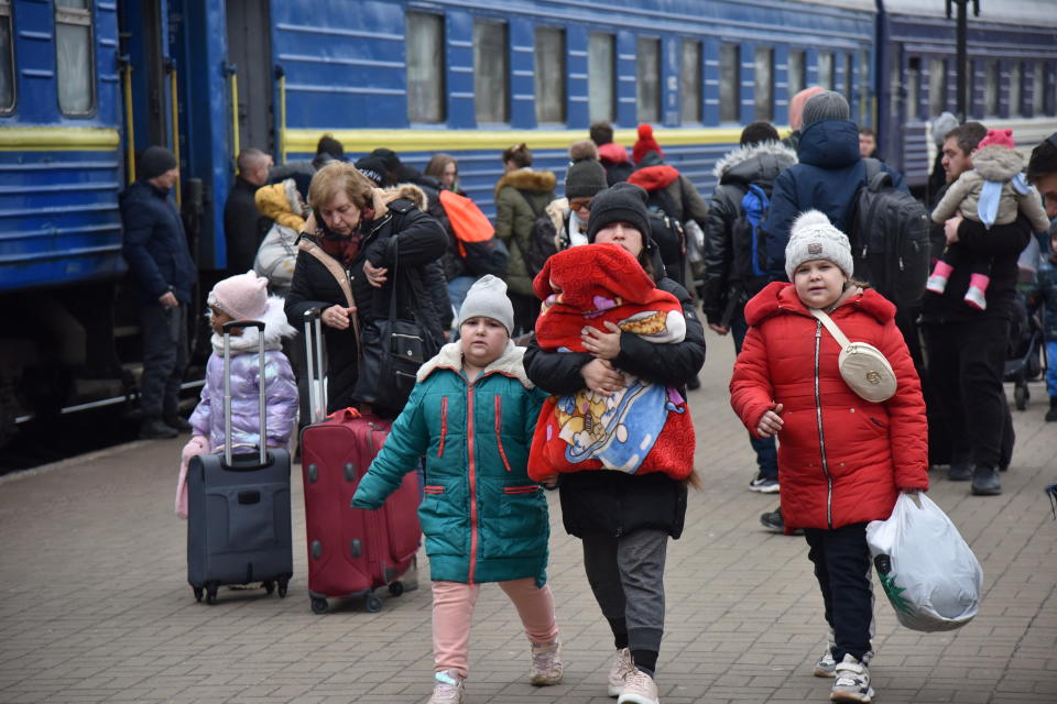 Passengers, including evacuees from the cities of Sumy and Kyiv, walk along the platform of a railway station upon their arrival in Lviv, Ukraine February 25, 2022. REUTERS/Pavlo Palamarchuk