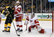 Detroit Red Wings goalie Jimmy Howard makes a save as defenseman Niklas Kronwall (55) and Boston Bruins' Patrice Bergeron look for the rebound during the second period of Game 1 of a first-round NHL playoff hockey series in Boston on Friday, April 18, 2014. (AP Photo/Winslow Townson)