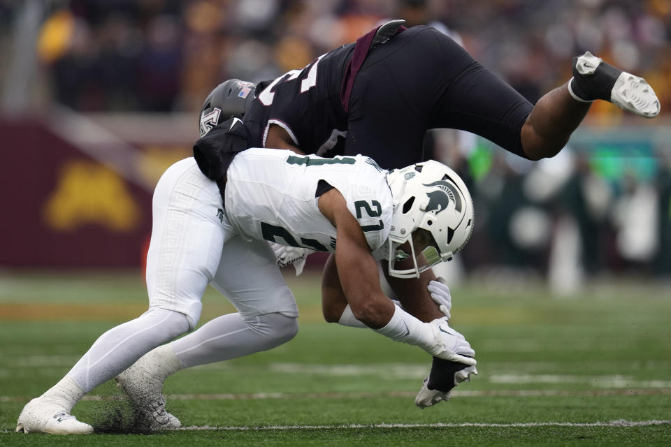 Minnesota running back Jordan Nubin, top, is tackled by Michigan State defensive back Dillon Tatum (21) during the first half of an NCAA college football game Saturday, Oct. 28, 2023, in Minneapolis. (AP Photo/Abbie Parr)