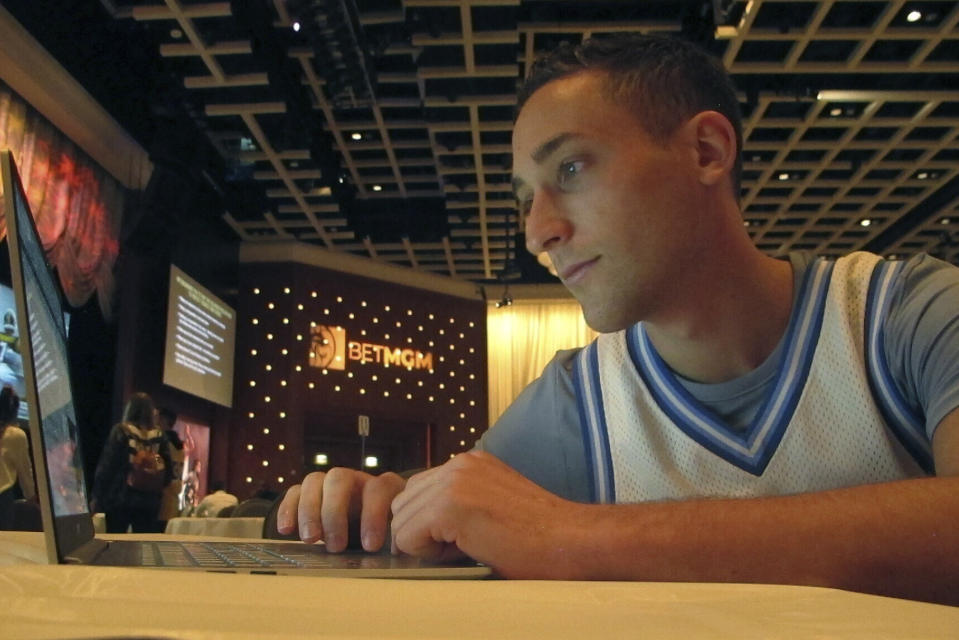 FILE- Jonathan Price of Staten Island, N.Y., researches picks for the March Madness college basketball championship tournament on March 19, 2021 at the Borgata casino in Atlantic City, NJ. On Tuesday, March 28, the American Gaming Association issued a new marketing code prohibiting sports books from partnering with colleges to promote sports wagering, banning payments to college and amateur athletes for the use of their name, image or likeness, and ending the use of terms including "free" or "risk-free" to describe promotional bets (AP Photo/Wayne Parry, File)