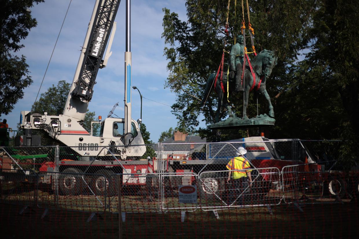 Workers remove a statue of Confederate General Robert E. Lee from Market Street Park July 10, 2021 in Charlottesville, Virginia.