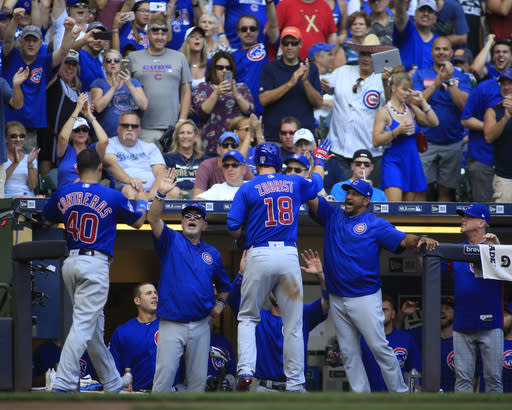 Chicago Cubs’ Ben Zobrist, center, celebrates his two-run home run against the Milwaukee Brewers as he enters the dugout during the seventh inning of an baseball game Sunday, Sept. 24, 2017, in Milwaukee. (AP Photo/Darren Hauck)