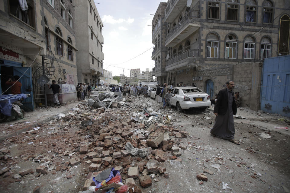 People inspect the site of an airstrike by Saudi-led coalition forces, in Sanaa, Yemen, Thursday, May, 16, 2019. Yemen's human rights minister says heavy fighting is underway in the country's south as rebel Houthis push to gain more territory from government forces and their allies. The clashes come as the Saudi-led coalition carried out airstrikes on the capital, Sanaa, earlier on Thursday, targeting the Houthis and killing at least three civilians. (AP Photo/Hani Mohammed)