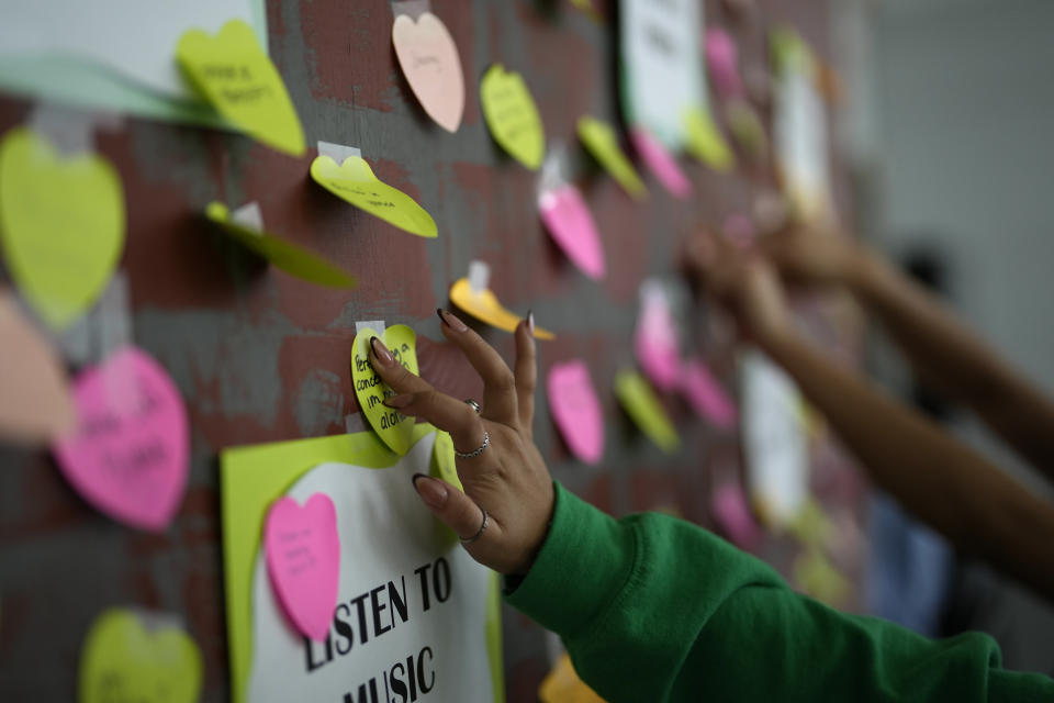 A student adds a note to others expressing support and sharing coping strategies, as members of the Miami Arts Studio mental health club raise awareness on World Mental Health Day, Tuesday, Oct. 10, 2023, at Miami Arts Studio, a public 6th-12th grade magnet school, in Miami. (AP Photo/Rebecca Blackwell)