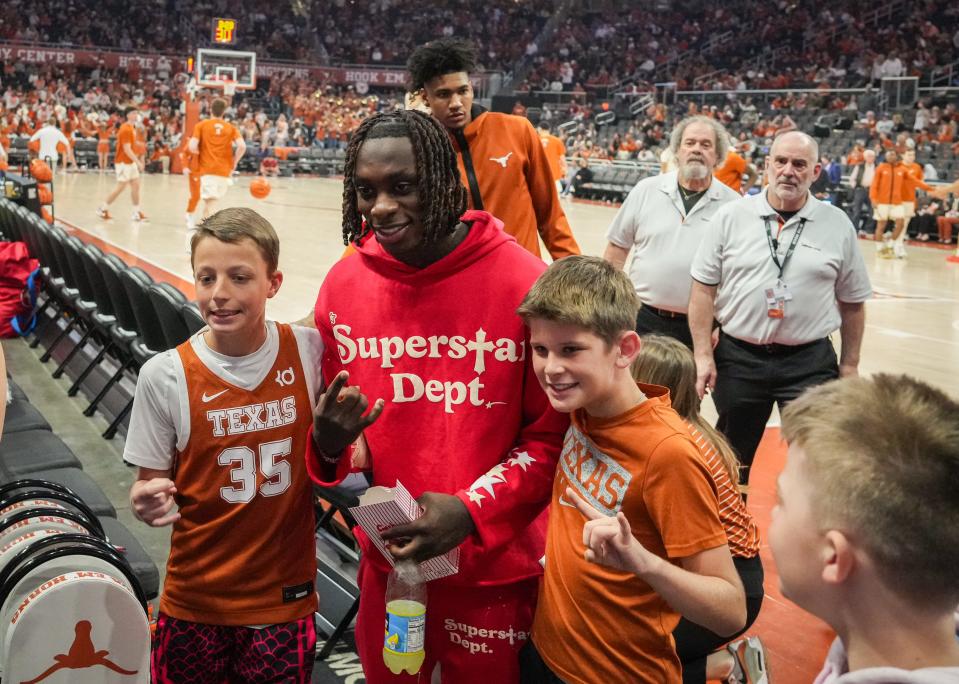 Former Texas wide receiver Xavier Worthy takes photos with fans during halftime of the March 9 Texas-Oklahoma men's basketball game at Moody Center. Worthy set an NFL scouting combine record in the 40-yard dash and could be back out there for Texas' annual pro day for NFL scouts.