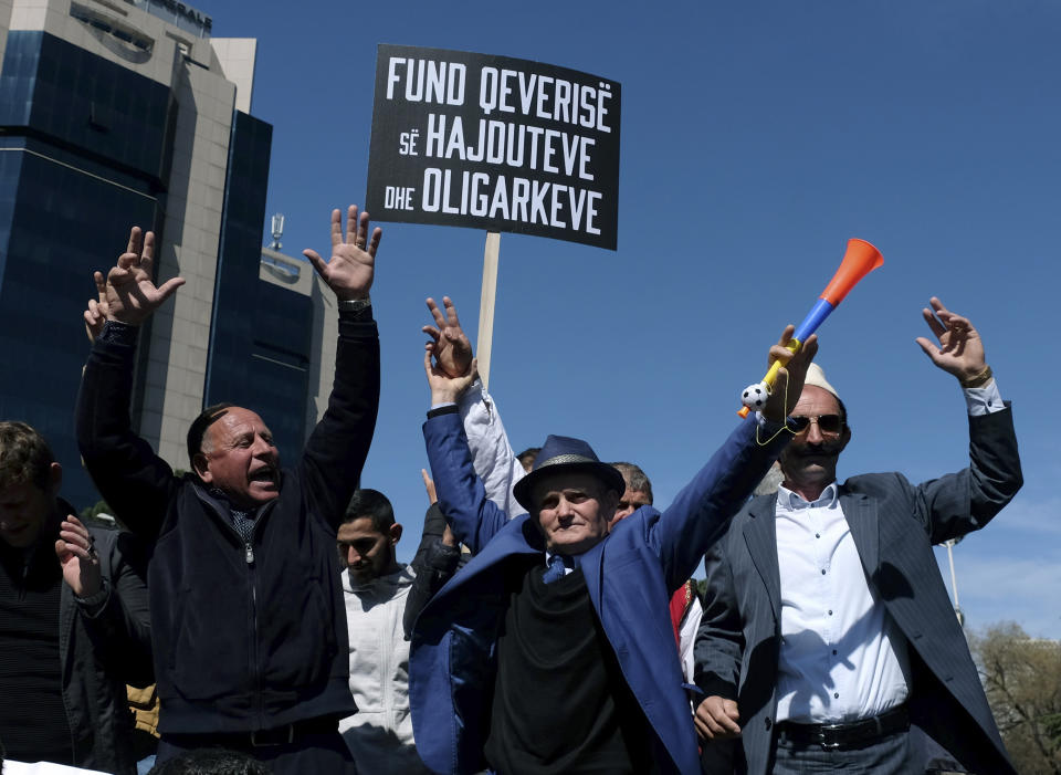 Protesters take part in an anti-government rally in Tirana, Albania, Saturday, March 16, 2019. Thousands of supporters of the center-right Democratic Party-led opposition have gathered on Saturday in front of Socialist Party's Prime Minister Edi Rama to demand his resignation, a transitory Cabinet without him that will prepare fresh elections. The banner reads : "End of the government of thieves and oligarchs" . (AP Photo/ Hektor Pustina)