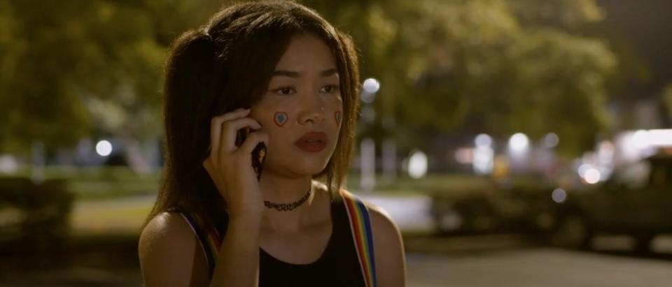 Young girl holding up a phone to her ears