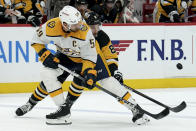 Nashville Predators' Roman Josi (59) and Pittsburgh Pittsburgh Penguins' Michael Bunting (8) fight for the puck during the second period of an NHL hockey game, Monday, April 15, 2024, in Pittsburgh. (AP Photo/Matt Freed)