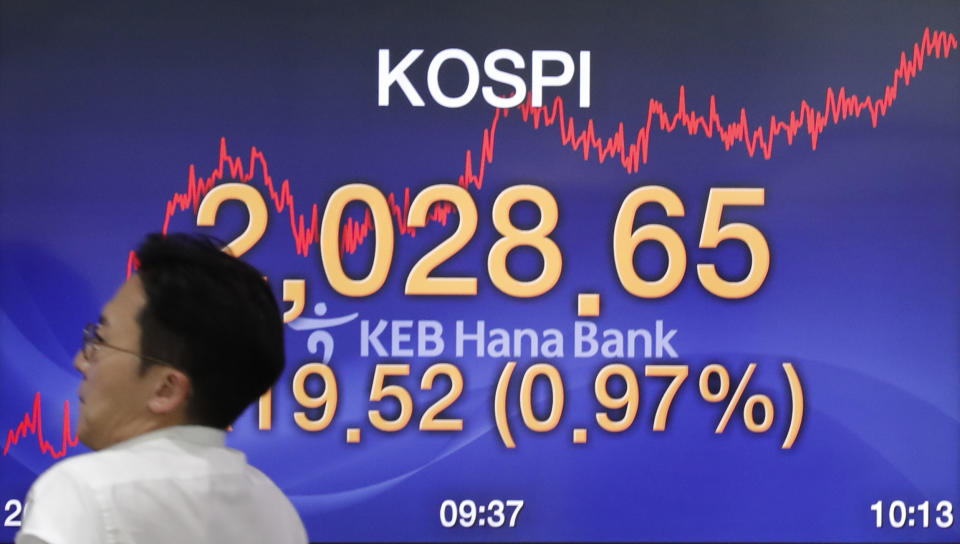 A currency trader walks by the screen showing the Korea Composite Stock Price Index (KOSPI) at the foreign exchange dealing room in Seoul, South Korea, Monday, Sept. 9, 2019. (AP Photo/Lee Jin-man)