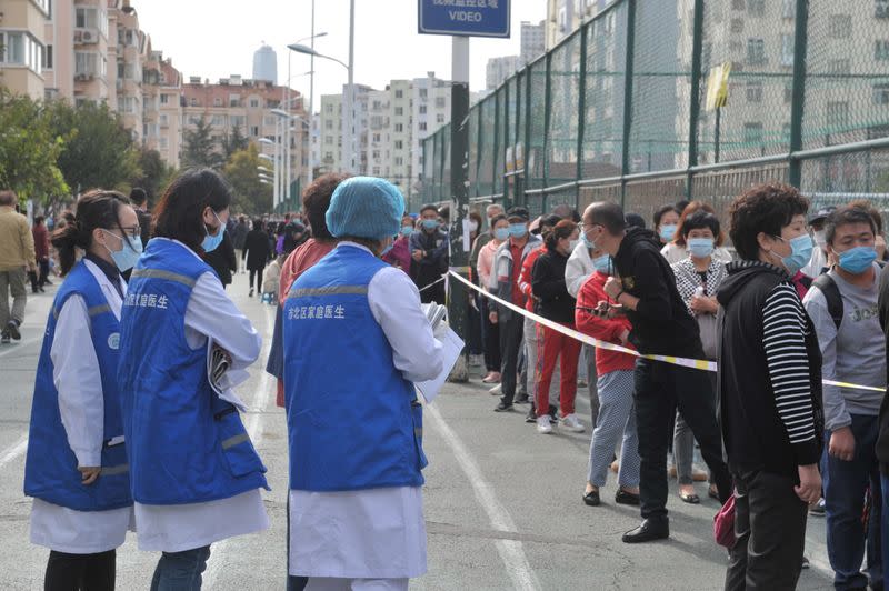 People wearing face masks line up for nucleic acid testing in Qingdao