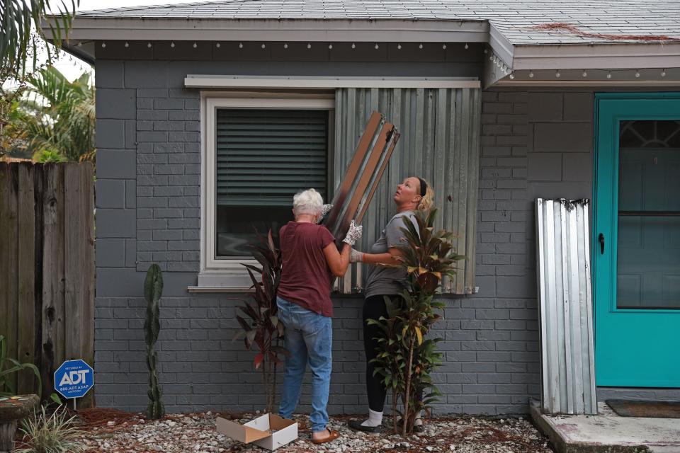 Rebecca Hale and her mother, Edda Howard, place shutters on her home as they prepare for the possible arrival of Hurricane Ian on September 27, 2022 in St Petersburg, Florida. Ian is expected in the Tampa Bay area Wednesday night into early Thursday morning.