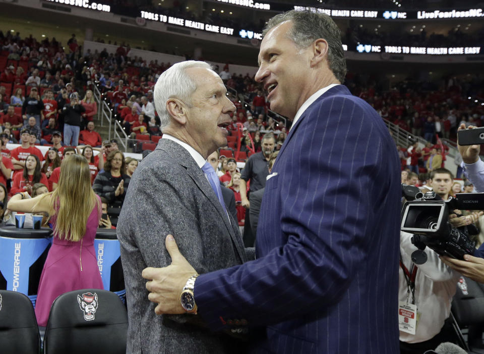 North Carolina coach Roy Williams, left, speaks with North Carolina State coach Mark Gottfried prior to an NCAA college basketball game in Raleigh, N.C., Wednesday, Feb. 15, 2017. (AP Photo/Gerry Broome)