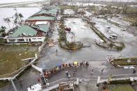 A damaged airport is seen as residents wait for relief goods after super Typhoon Haiyan battered Tacloban city, central Philippines, November 9, 2013. Possibly the strongest typhoon ever to hit land devastated the central Philippine city of Tacloban, killing at least 100 people, turning houses into rubble and leveling the airport in a surge of flood water and high wind, officials said on Saturday. The toll of death and damage from Typhoon Haiyan on Friday is expected to rise sharply as rescue workers and soldiers reach areas cut off by the massive, fast-moving storm which weakened to a category 4 on Saturday. REUTERS/Romeo Ranoco (PHILIPPINES - Tags: DISASTER ENVIRONMENT)