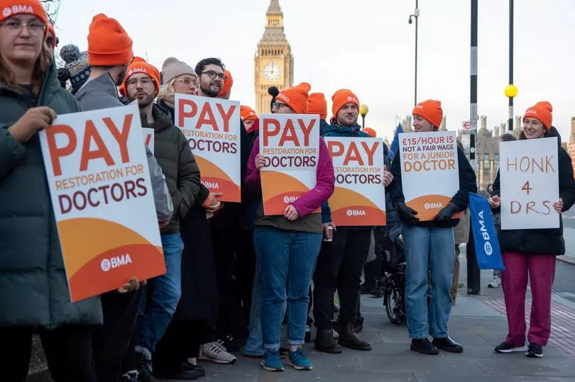 Protesters hold placards expressing their opinion during a demonstration outside of the St Thomas Hospital in London. Big Ben is seen it the distance