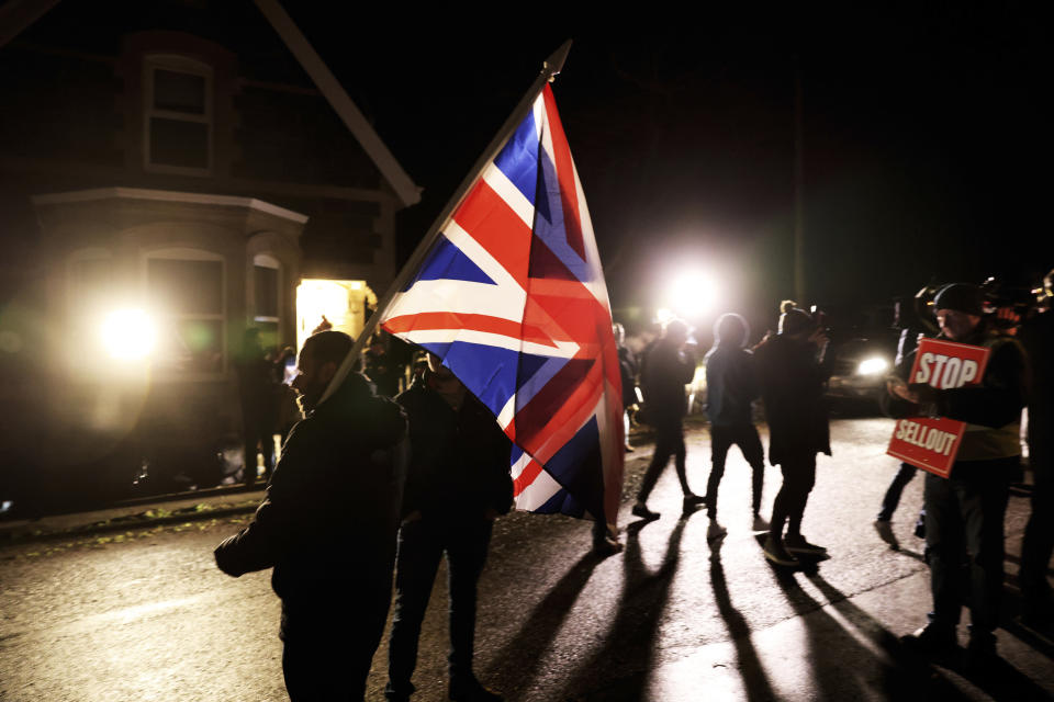 Loyalists protest outside the grounds were the Democratic Unionist Party executive meeting is taking place at Larchfield Estate in Lisburn, Northern Ireland, Monday, Jan. 29, 2024. The Unionist leader is meeting with his executive members to work on a deal to restore power-sharing at Stormont on Monday. The 130 strong-party executive was invited at short notice Monday to a secure venue as it is expected to be picked by Loyalist protesters opposed to returning to power. (AP Photo/Peter Morrison)