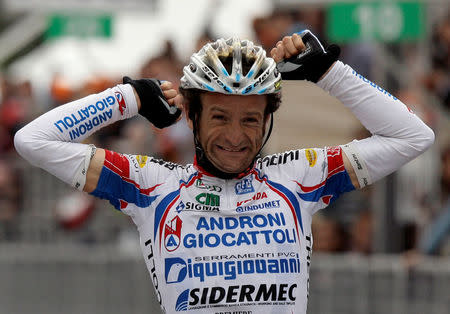 FILE PHOTO: Androni-Diquigiova team rider Michele Scarponi of Italy celebrates his victory as he crosses the finish line of the 195-km 19th stage of the Giro d'Italia cycling race from Brescia to Aprica May 28, 2010. REUTERS/Alessandro Garofalo/File Photo