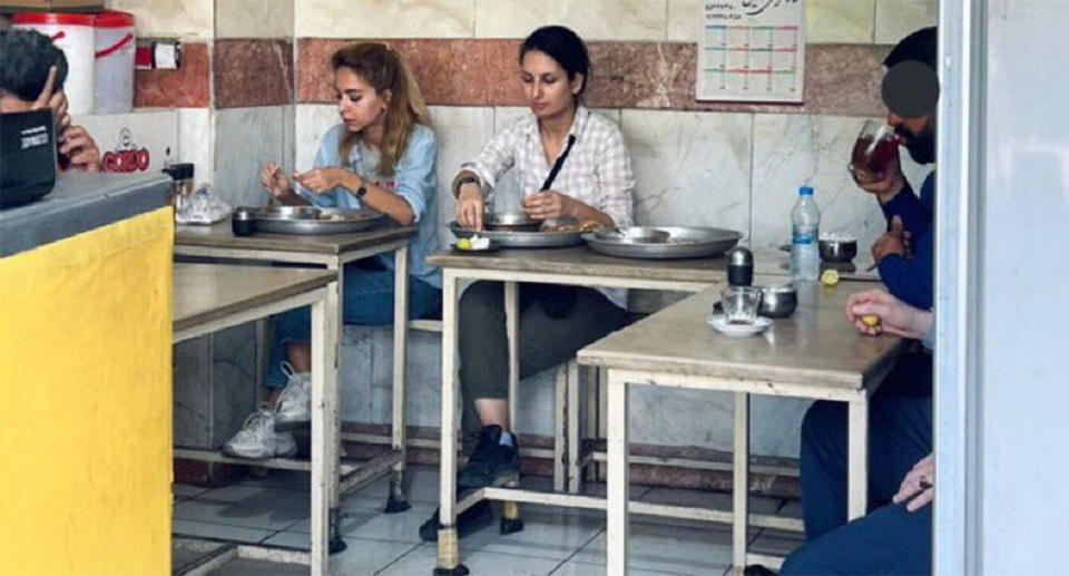 Donya Rad and a friend sit at a cafe in Tehran without headscarves