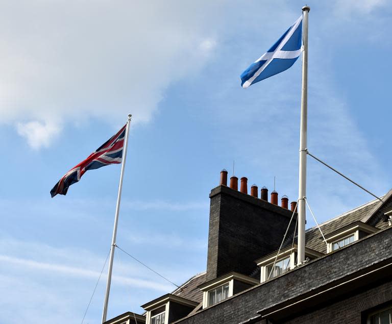 The Scottish flag (R) flutters next to the Union flag over Downing Street in London on September 9, 2014