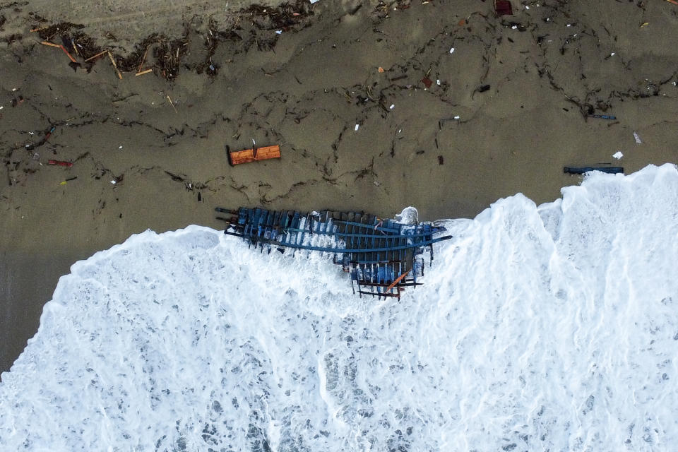 A view of part of the wreckage of a capsized boat that was washed ashore at a beach near Cutro, southern Italy, Monday, Feb. 27, 2023. Rescue crews searched by sea and air Monday for the dozens of people believed still missing from a shipwreck off Italy’s southern coast that drove home once again the desperate and dangerous crossings of migrants seeking to reach Europe. (AP Photo/Luigi Navarra)