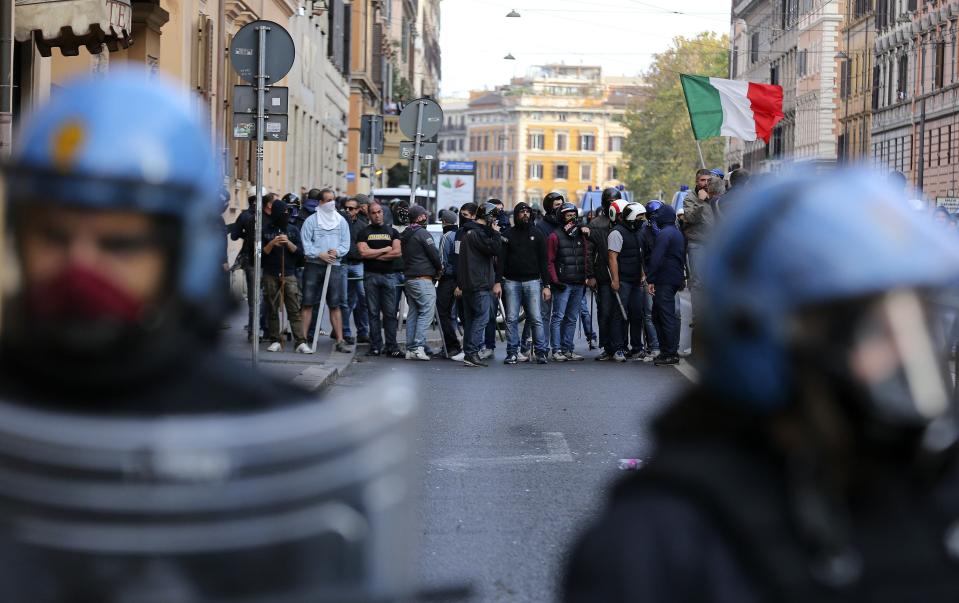 Riot policemen frame demonstrators during a protest in downtown Rome