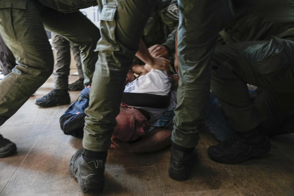 Israeli police officers detain a demonstrator during a protest against plans by Prime Minister Benjamin Netanyahu's government to overhaul the judicial system, at the Ben Gurion Airport in Lod, near Tel Aviv, Israel, Monday, July 3, 2023. (AP Photo/Ohad Zwigenberg)