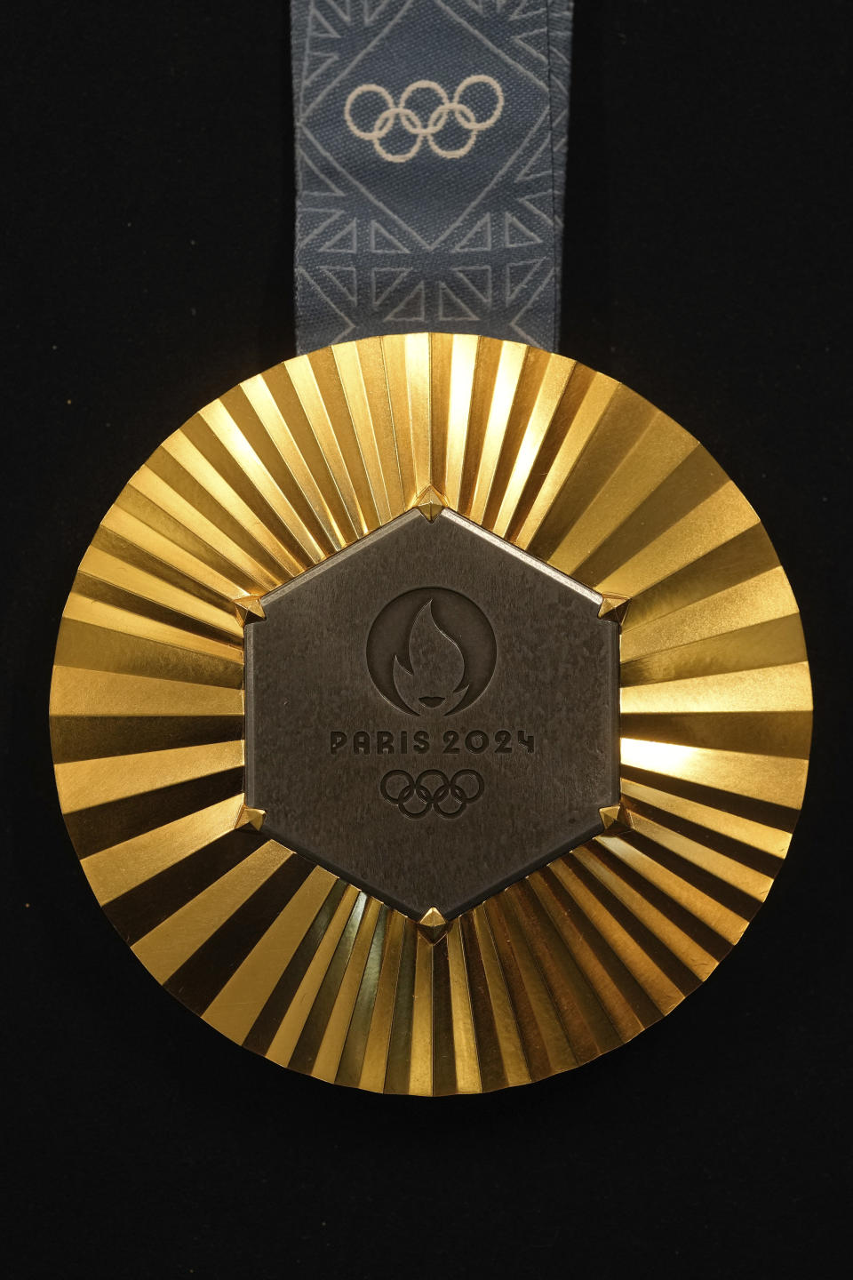 The Paris 2024 Olympic gold medal is presented to the press, in Paris, Thursday, Feb. 1, 2024. A hexagonal, polished piece of iron taken from the Eiffel Tower is being embedded in each gold, silver and bronze medal that will be hung around athletes' necks at the July 26-Aug. 11 Paris Games and Paralympics that follow. (AP Photo/Thibault Camus)