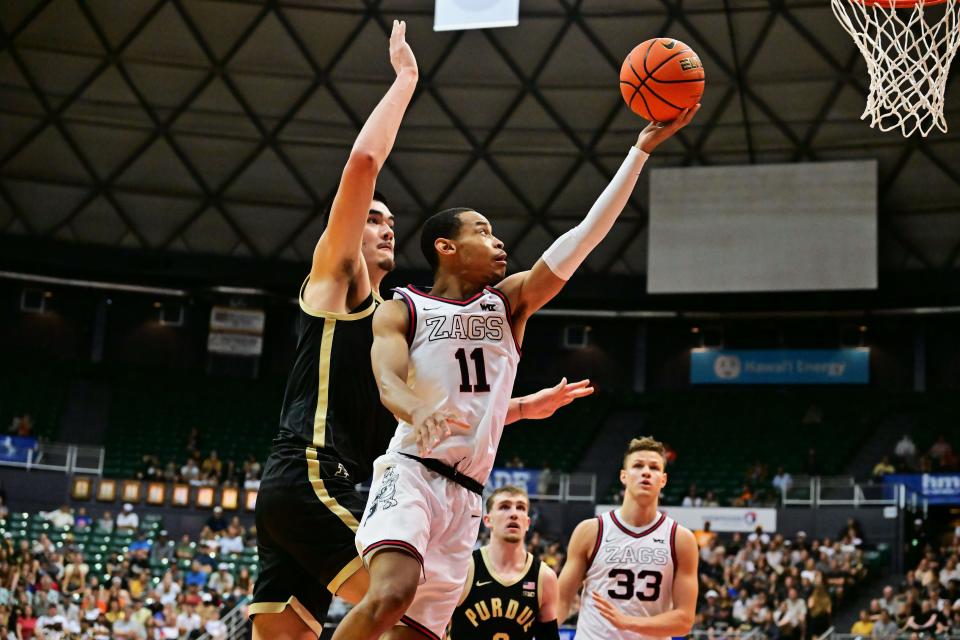 Gonzaga guard Nolan Hickman (11) drives to the basket defended by Purdue center Zach Edey (15) during their Maui Invitational game at SimpliFi Arena at Stan Sheriff Center in Honolulu.