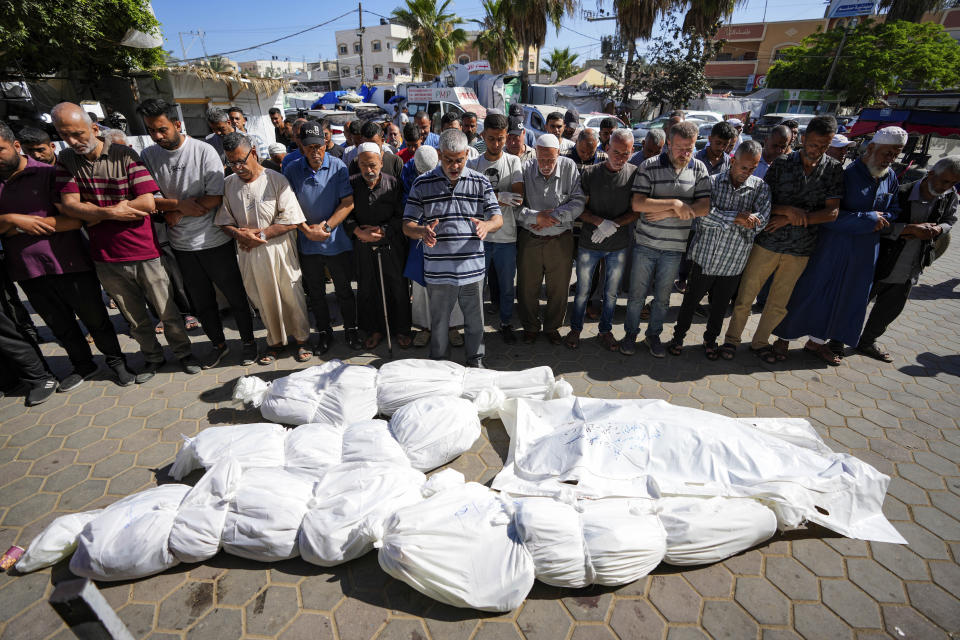 Mourners pray over the bodies of Palestinians, a day after they were killed by Israeli bombardment, at their funeral at Al Aqsa Hospital in Deir al Balah, Friday, May 24, 2024. (AP Photo/Abdel Kareem Hana)