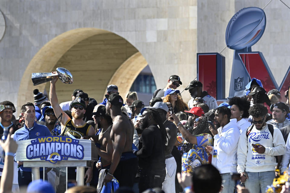 Los Angeles Rams wide receiver Cooper Kupp holds up the Vince Lombardi Super Bowl trophy at left during the team's victory celebration in Los Angeles, Wednesday, Feb. 16, 2022, following their win Sunday over the Cincinnati Bengals in the NFL Super Bowl 56 football game. (AP Photo/Kyusung Gong)