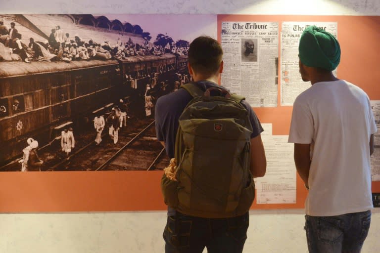 Visitors look at photographs and newspaper clippings at the Partition Museum in India's Amritsar