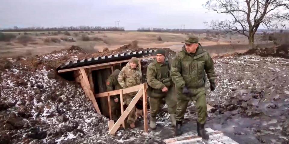 In this handout photo taken from video released by Russian Defense Ministry Press Service on Thursday, Dec. 22, 2022, Russian Defense Minister Sergei Shoigu, center, walks out of a trench, escorted by a group of officers as he inspects Russian troops at an undisclosed location in Ukraine.