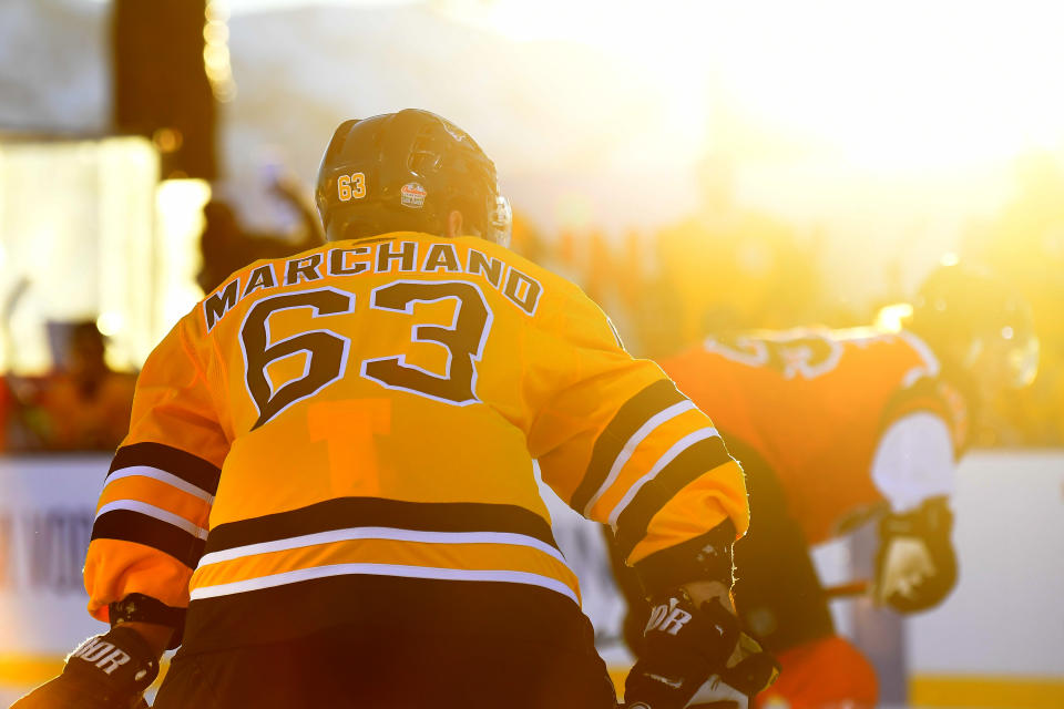 <p>Brad Marchand #63 of the Boston Bruins is seen in the sunset while playing against the Philadelphia Flyers during the first period of the 2021 NHL Outdoors Sunday presented by Honda on the 18th fairway of the Edgewood Tahoe Resort, at the south shore of Lake Tahoe on February 21, 2021 in Stateline, Nevada. (Photo by Brian Babineau/NHLI via Getty Images)</p> 