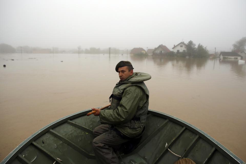 A Serbian army soldier rows a boat as he searches for people to be evacuated in the town of Obrenovac