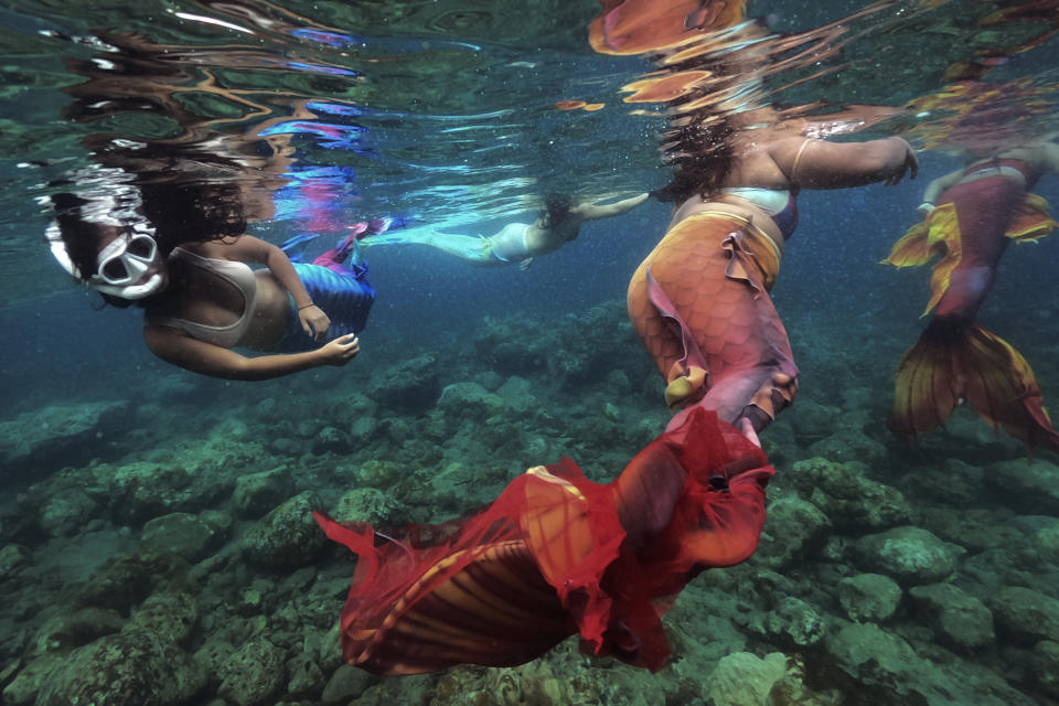 Jennica Secuya (izq) y otras estudiantes participan en una clase para nadar como sirenas en Mabini (Filipinas) el 22 de mayo del 2022. (AP Photo/Aaron Favila)